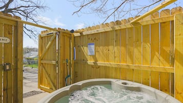 A wooden gate with a sign that reads "Welcome," leading to a hot tub area.