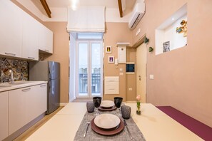A modern kitchen with a dining area set for four. - Toledo Warm Renovated Studio (Naples)