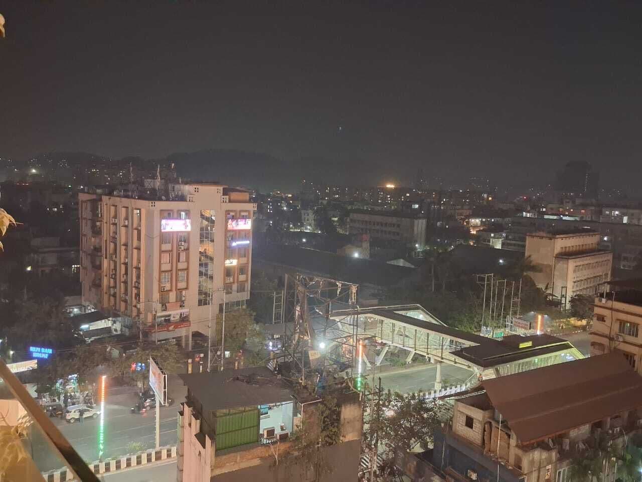 Un paisaje urbano nocturno con edificios iluminados y un puente.