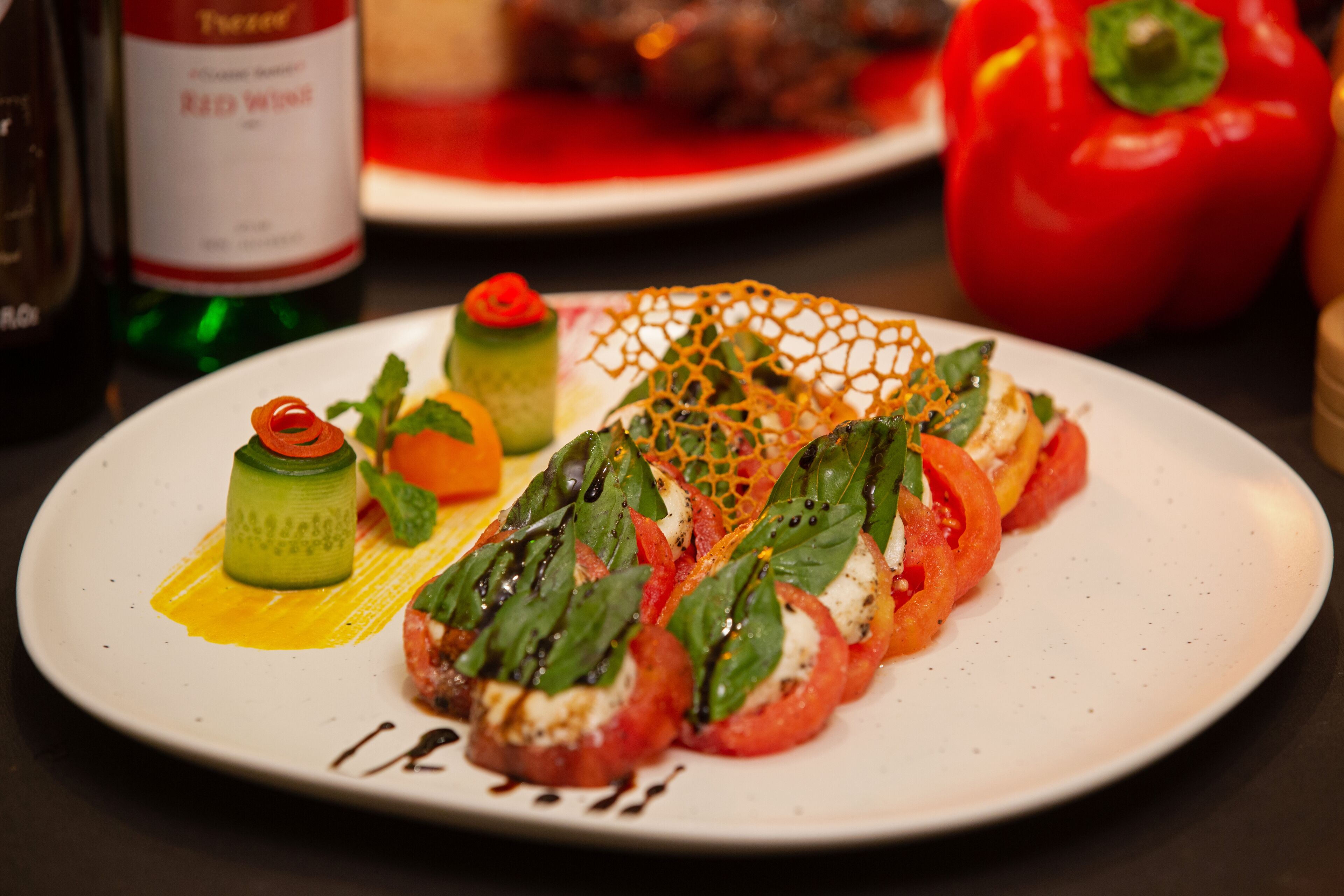 Un plato de comida con un pimiento rojo, un pepino y un tomate.