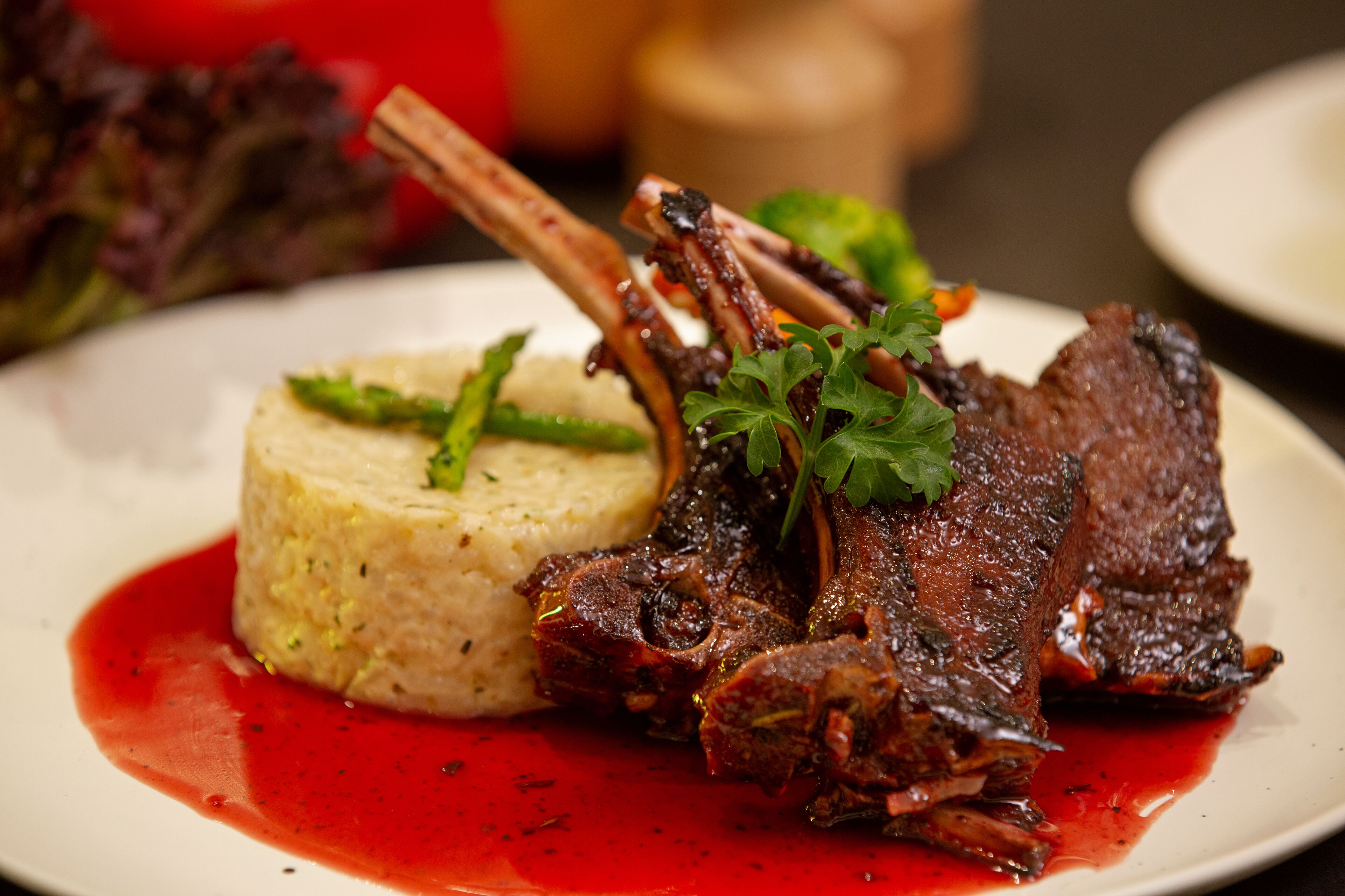 A plate with a meat dish, mashed potatoes, and a red sauce.