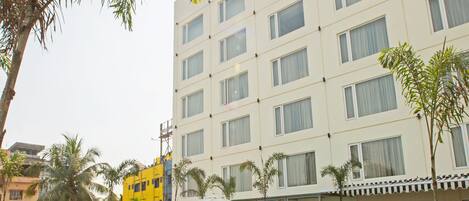 Un hotel llamado ARISTA con piscina rodeada de vegetación.