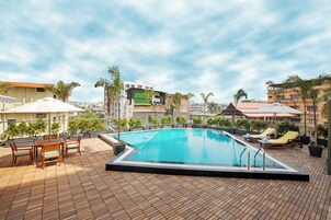Una piscina al aire libre, sombrillas