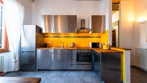 A modern kitchen with stainless steel appliances, a central island, and a tiled backsplash. - Casa Bodoni in Rome With 2 Bedrooms and 2 Bathrooms (Rome)