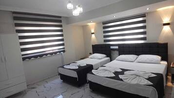 A hotel room with two beds, a wardrobe, and a bathroom.
