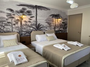 A hotel room with two beds, a mural of tropical foliage, and a door. - Olive House (Denizli)