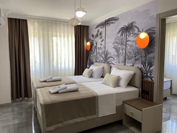Une chambre d’hôtel avec un grand lit, une table de chevet, un miroir et une fresque murale aux motifs tropicaux.