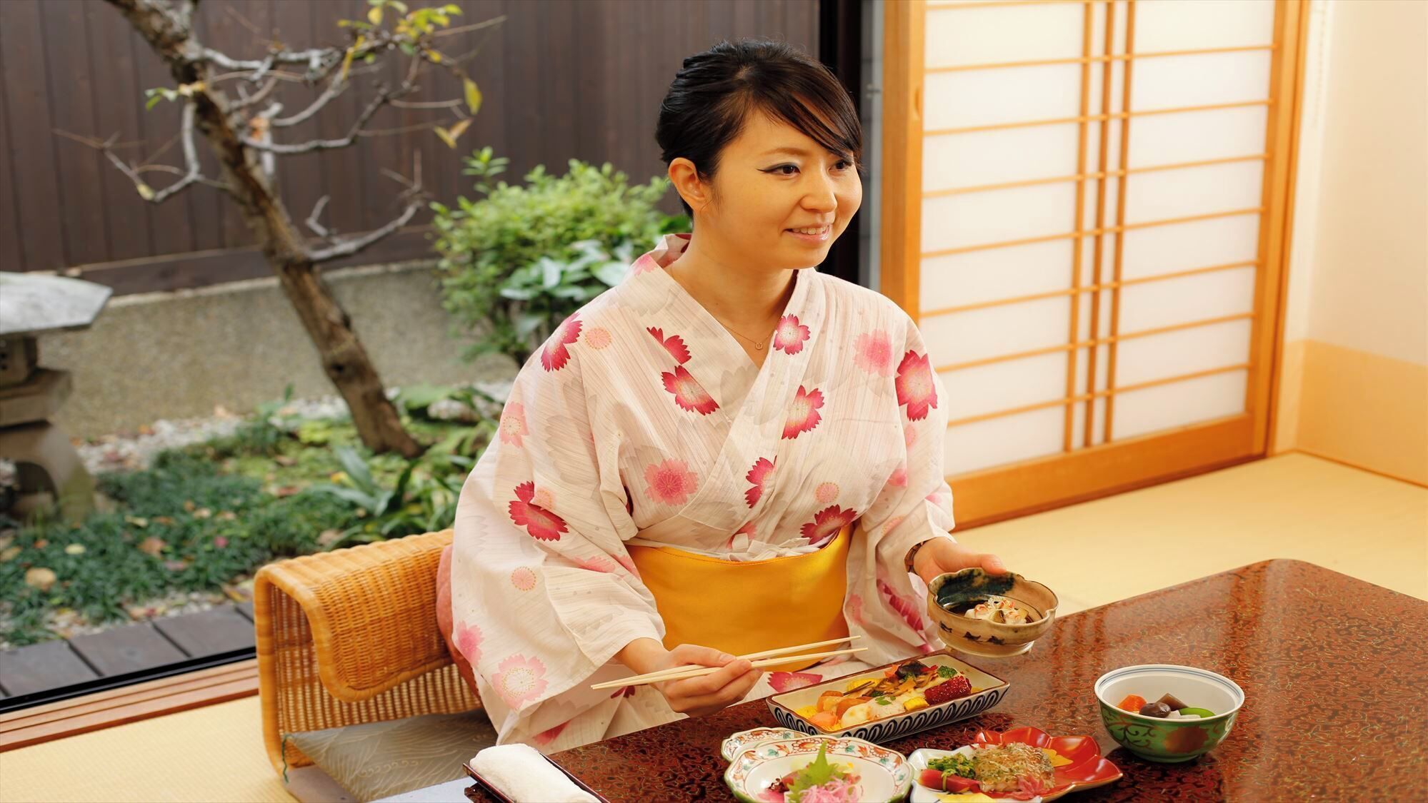 A traditional Japanese room with tatami flooring, a low table, and a shoji screen.