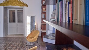 A room with a bookshelf, a door, and a patterned floor. - Casa Paola in Syracuse (Syracuse)