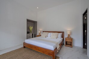 Une chambre moderne avec un lit en bois, deux tables de chevet avec des lampes, une petite commode en bois et un miroir.