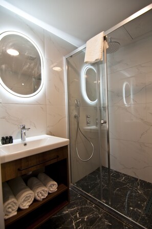 Habitación cuádruple Deluxe | Baño | Ducha y cabezal de ducha tipo lluvia