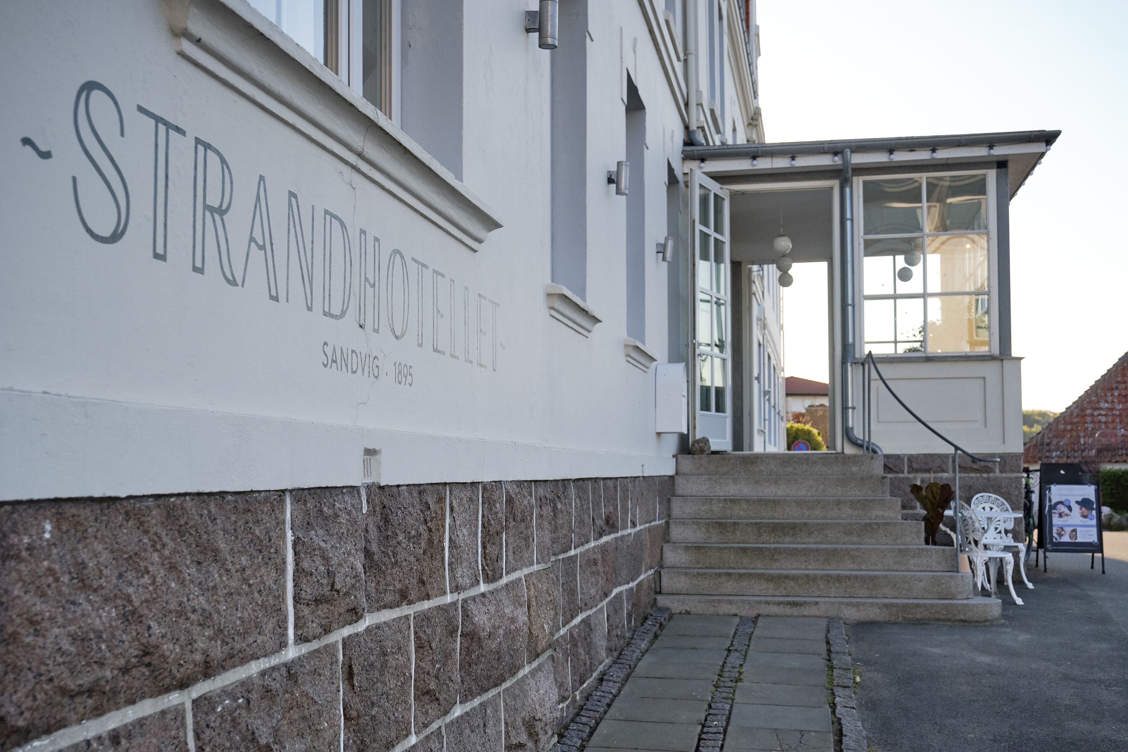 A building with a sign reading "STRANDHOTEL" and the year "1895".