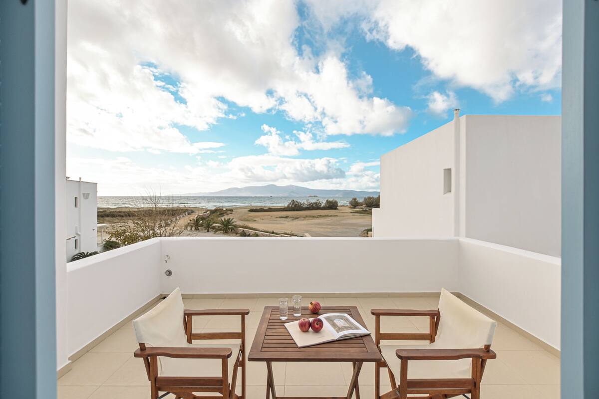 A balcony with a table, chairs, and a book.