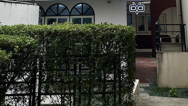 A building with a white facade, multiple windows, and a balcony with string lights. - Sleep Owl Chiang Mai  (Chiang Mai)