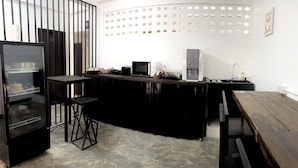 A modern kitchen with a black countertop, a refrigerator, a microwave, and a water dispenser. - Sleep Owl Chiang Mai  (Chiang Mai)