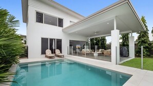 A modern two-story house with a swimming pool, outdoor seating, and a covered patio area. - Beachmont Bliss Palm Cove 3 Bedroom Holiday Home (Palm Cove)