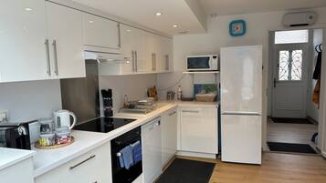 Een koffiezetapparaat/waterkoker, kookgerei, borden en bestek