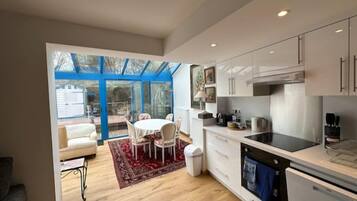 Een koffiezetapparaat/waterkoker, kookgerei, borden en bestek