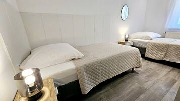 Une chambre d’hôtel avec un lit, une table de chevet, une lampe et un miroir au mur.