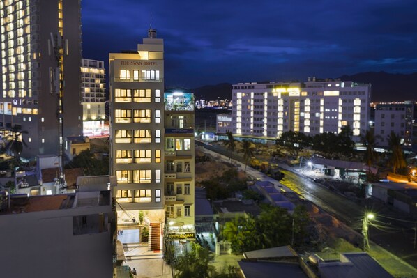 A multi-story hotel with illuminated windows and a sign reading "The Swan Hotel".