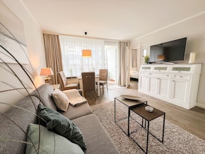 Relax in a spacious room with a comfortable sofa set, coffee table, and large window.