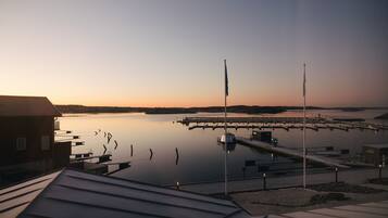 A marina with calm water, docks, and a building with a sloped roof.