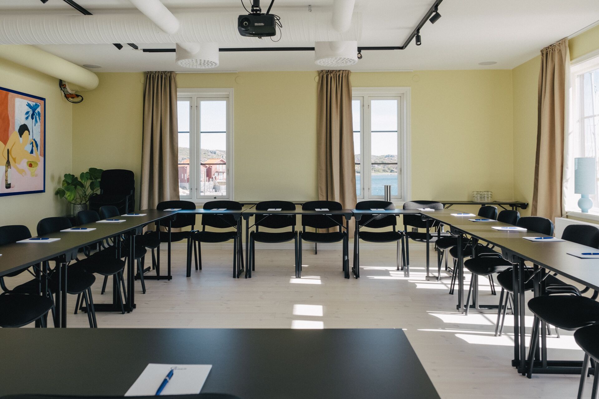 A conference room with a long table, chairs, and a projector.