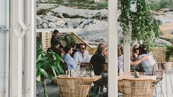 An outdoor seating area with wicker furniture and a view of rocky terrain.