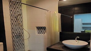 A modern bathroom with a shower, toilet, and sink. - OYO 93808 Lincoln Dormitory (Curug)