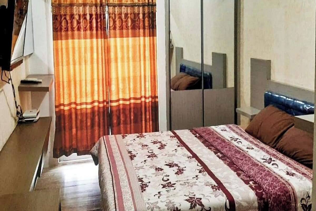 Une chambre d’hôtel équipée d’un lit, d’une armoire, d’un climatiseur et d’un téléviseur.