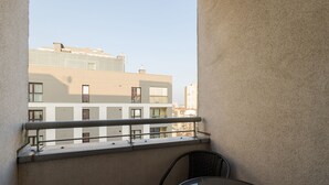 A balcony with a table and chairs, overlooking a row of buildings. - ShortStayPoland Aleja Stanów Zjednoczonych (B159) (Warsaw)