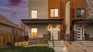 A modern two-story house with a stone and wood facade, a front door, and a visible address number. - Spacious Denver Home with Hot tub and Rooftop (Denver)