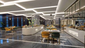 Uma sala de jantar moderna com ilha central, diversas opções de assento e teto bem iluminado com luminárias lineares.