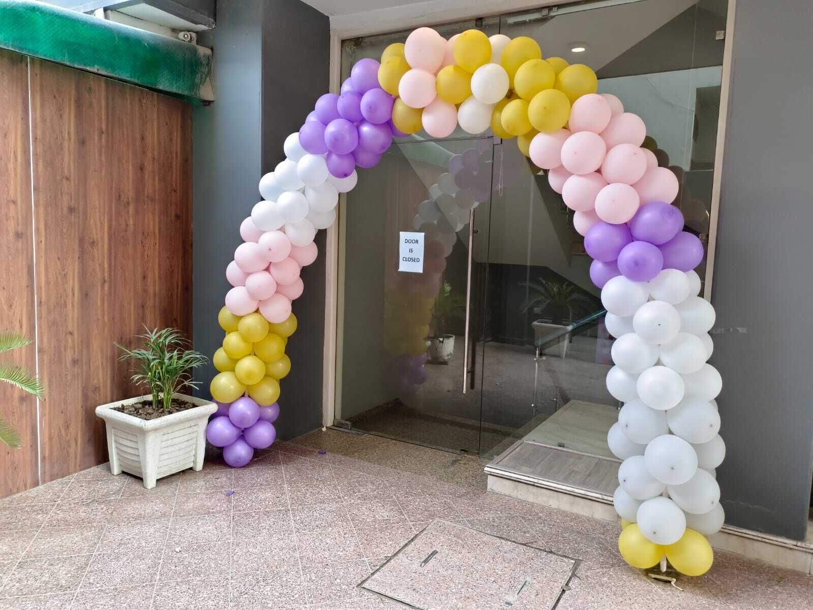 A glass door entrance with a balloon arch.