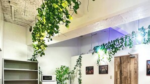 A conference room with a wooden table, black chairs, a whiteboard, and green plants. - Tranquil Getaway in the Heart of the City (中野区)