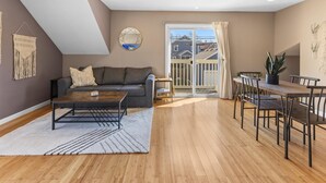 Un salon comprenant un canapé, une table basse et un coin repas avec des chaises.