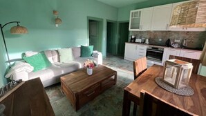 Una sala de estar acogedora con sofá, mesa de centro y comedor con mesa y sillas de madera.