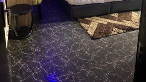 Une chambre à coucher moderne avec un lit, un bureau, une chaise et un téléviseur.