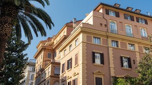 A multi-story building with classical architecture, featuring balconies and large windows. - Numa Rome Barberini (Rome)