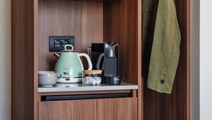 A kitchenette with a vintage-style kettle, a coffee maker, and a small cabinet. - Numa Rome Barberini (Rome)
