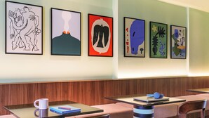 A modern restaurant with wooden paneling, striped chairs, and abstract art on the wall. - Numa Rome Barberini (Rome)
