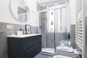 A modern bathroom with a shower, toilet, and sink. - Easylife - Apartment with terrace near Cenacolo (Milano)