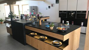 Una cocina moderna con una isla central, armarios de madera y encimera negra.