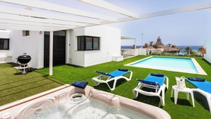 A rooftop pool area with a hot tub, lounge chairs, and a view of the ocean. - Luxury Villa with Stunning Ocean & Mountain View’s (Montaña Roja)