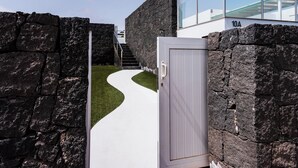 A modern building with a stone facade, a white door, and a glass balcony. - Luxury Villa with Stunning Ocean & Mountain View’s (Montaña Roja)
