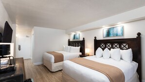 Ett hotellrum med två sängar, en tv och en tavla på väggen.