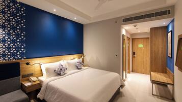 Una habitación de hotel moderna con una cama grande, una mesita de noche y un panel decorativo en la pared.