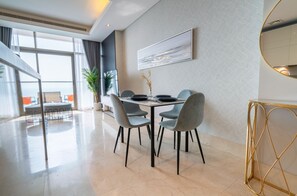 Un espace repas moderne avec une table et des chaises, une grande fenêtre offrant une belle vue et un élément décoratif mural.