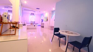 Un moderno vestíbulo de hotel con una recepción, zona de estar y un amplio ventanal.