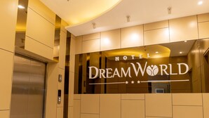 Un moderno vestíbulo de hotel con techo curvo, una recepción y un ascensor.